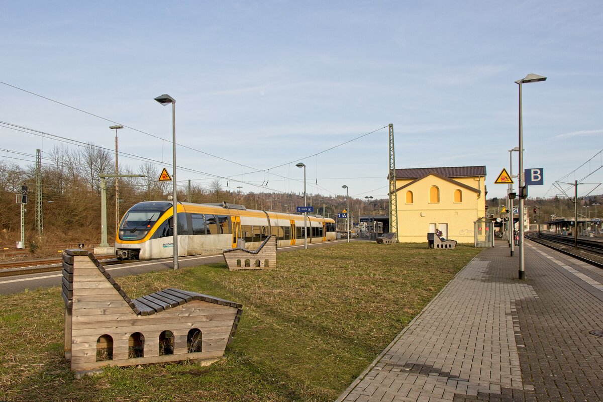 Sitzgelegenheiten mit Viadukt-Verzierung im Bahnhof Altenbeken, im Hintergrund VT 2.04a der Eurobahn (13.02.2022)
