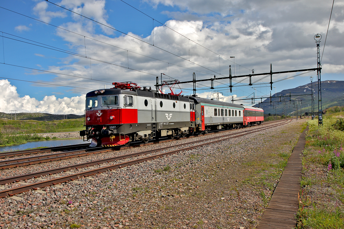 Sj Lok Rc 1327 zieht den Sj Abisko Touristenzug Nattaget 10094 aus Gällivare kommend nach Narvik bei Vassijaure durch.Bild vom 19.7.2014