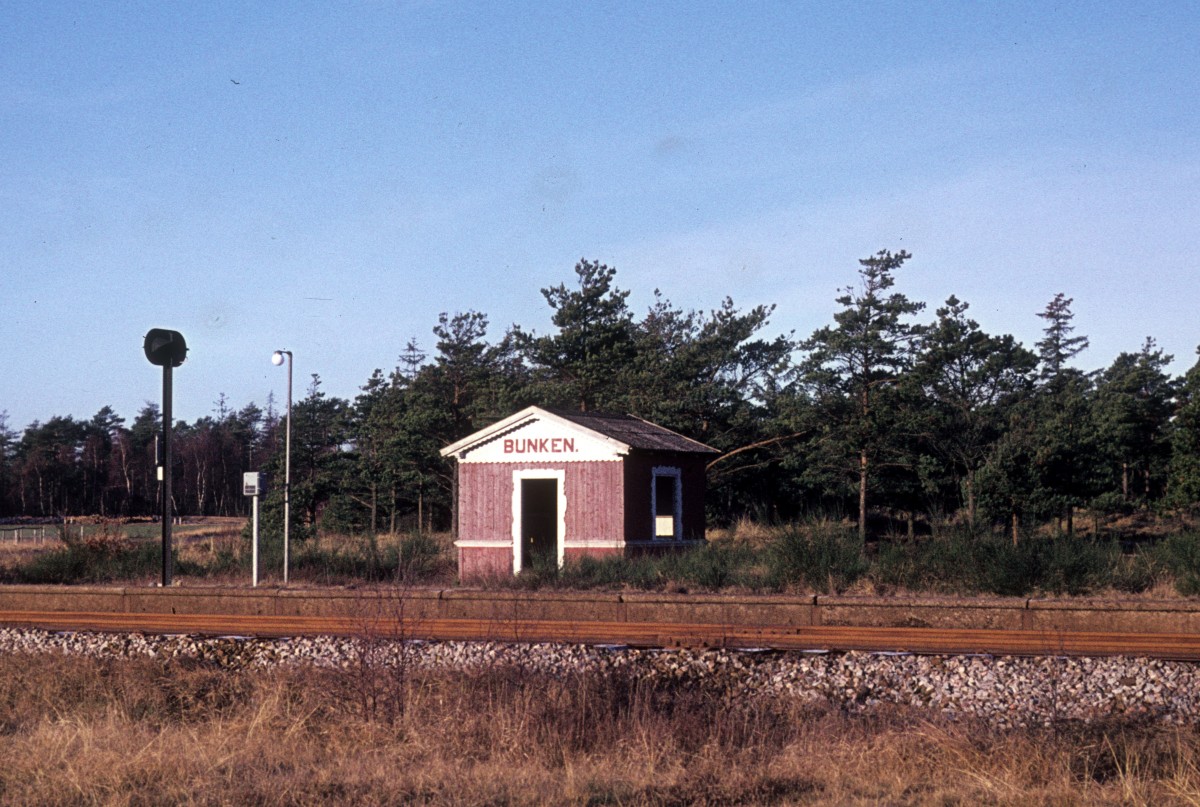Skagensbanen: Haltepunkt Bunken am 25. Februar 1975. Im selben Jahr wurde das Holzgebäude abgerissen und durch ein neues Wartehäuschen ersetzt. - Der Haltepunkt wird heute von den Triebzügen des Unternehmens Nordjyske Jernbaner bedient.