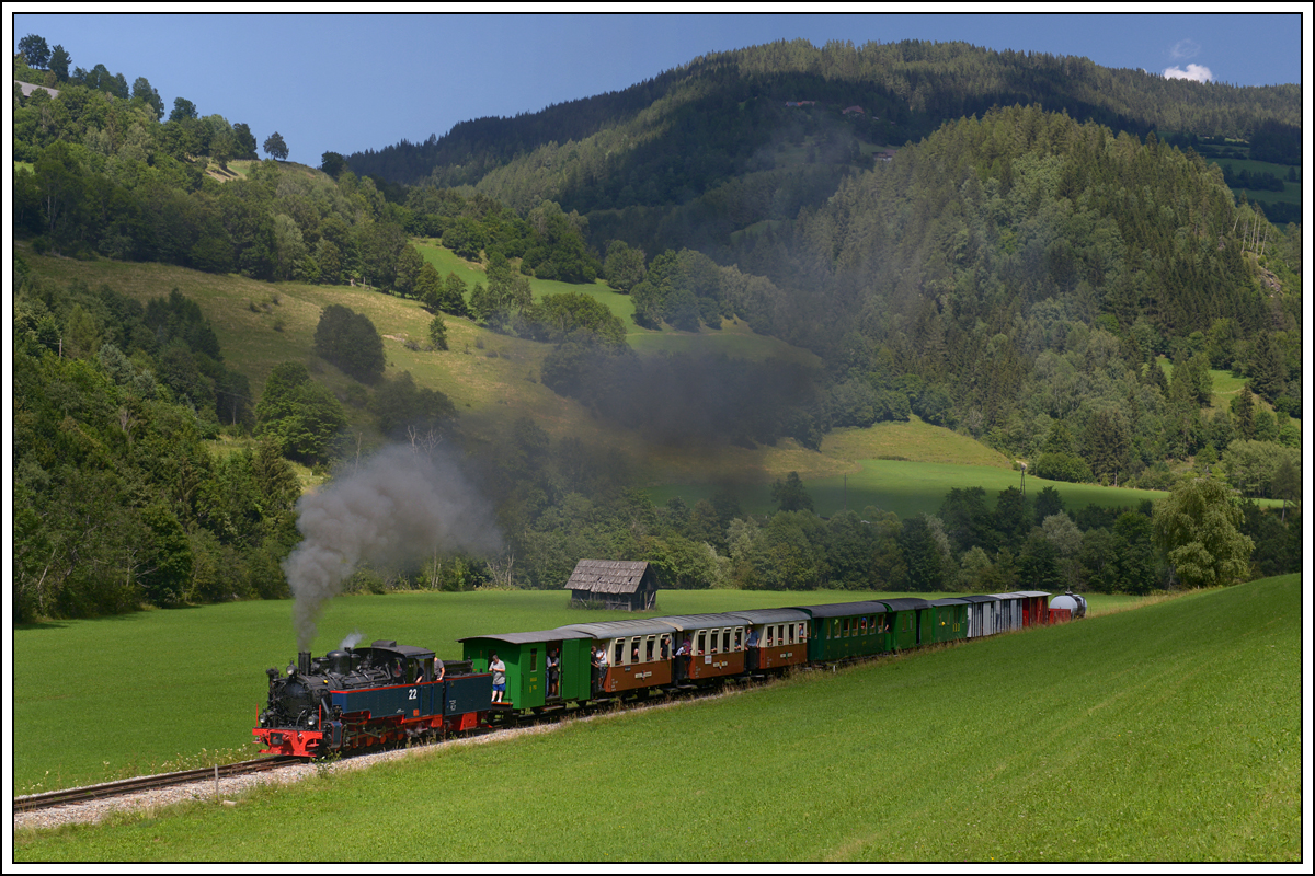 SKGLB 22 (Aquarius C) bespannte am 19.7.2018 einen Sonderzug von Mauterndorf in der Ferienregion Lungau, nach Murau und wieder retour. Die Aufnahme zeigt den Zug bei der Retourfahrt kurz nach der Ausfahrt aus der Ausweiche Wandritsch.