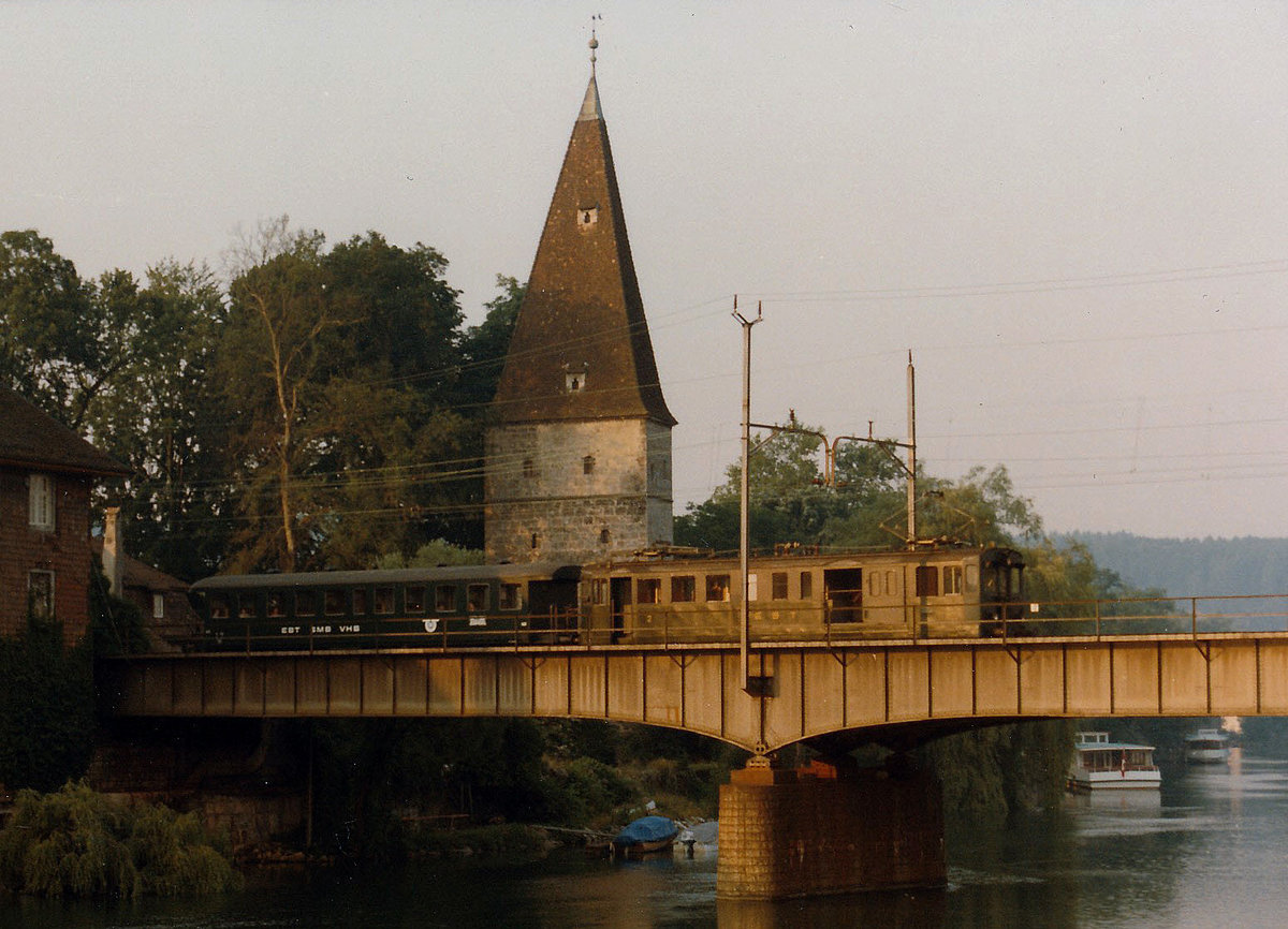 SMB:  An einem schönen Morgen im Mai 1984 bei Sonnenaufgang wurde ein  Regionalzug nach Moutier bestehend aus einem BDe 2/4 221 mit einem sehr seltenen Stahl B (ehemals SBB) beim Passieren des krummen Turms auf der Aarebrücke Solothurn verewigt. Normalerweise wurde damals ein BD mitgeführt.
Foto: Walter Ruetsch