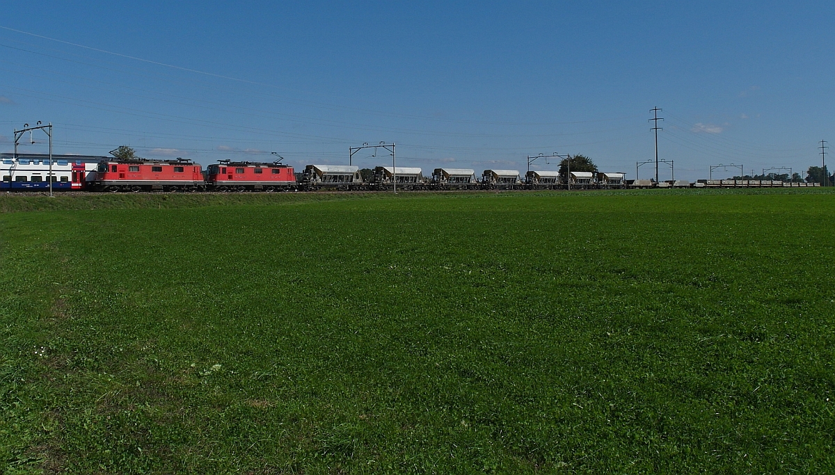 So ein Pech aber auch. Kurz bevor das Objekt der Begierde, ein von zwei Re 4/4 III, Nrn. 11362 und 11369, gezogener Schüttgutwagenzug den Fotostandort erreicht, beginnt ein aus Richtung Amriswil kommender RABe 511 auf Test-/Probefahrt mit dem Überholvorgang. Trotz höherer Geschwindigkeit des RABe 511 hat er es bei Engishofen (TG) noch nicht geschafft, den Güterzug vollständig zu überholen (28.09.2015).