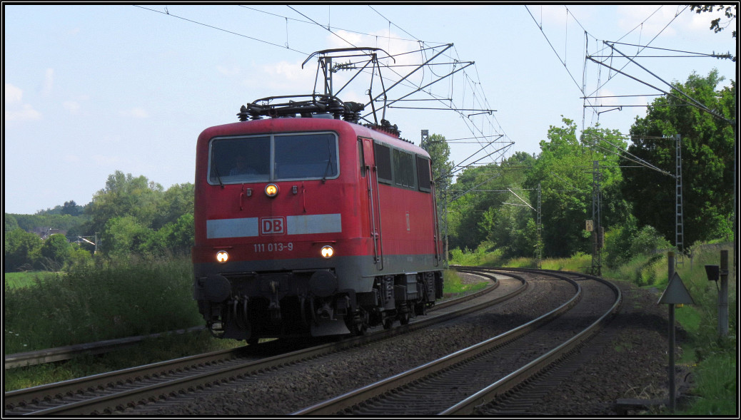 Solo geht es für die 111 013-9 nach Aachen, hier zu sehen im Gleisbogen auf der Kbs 485 bei Rimburg am Bahnübergang, 10.Juni 2015.