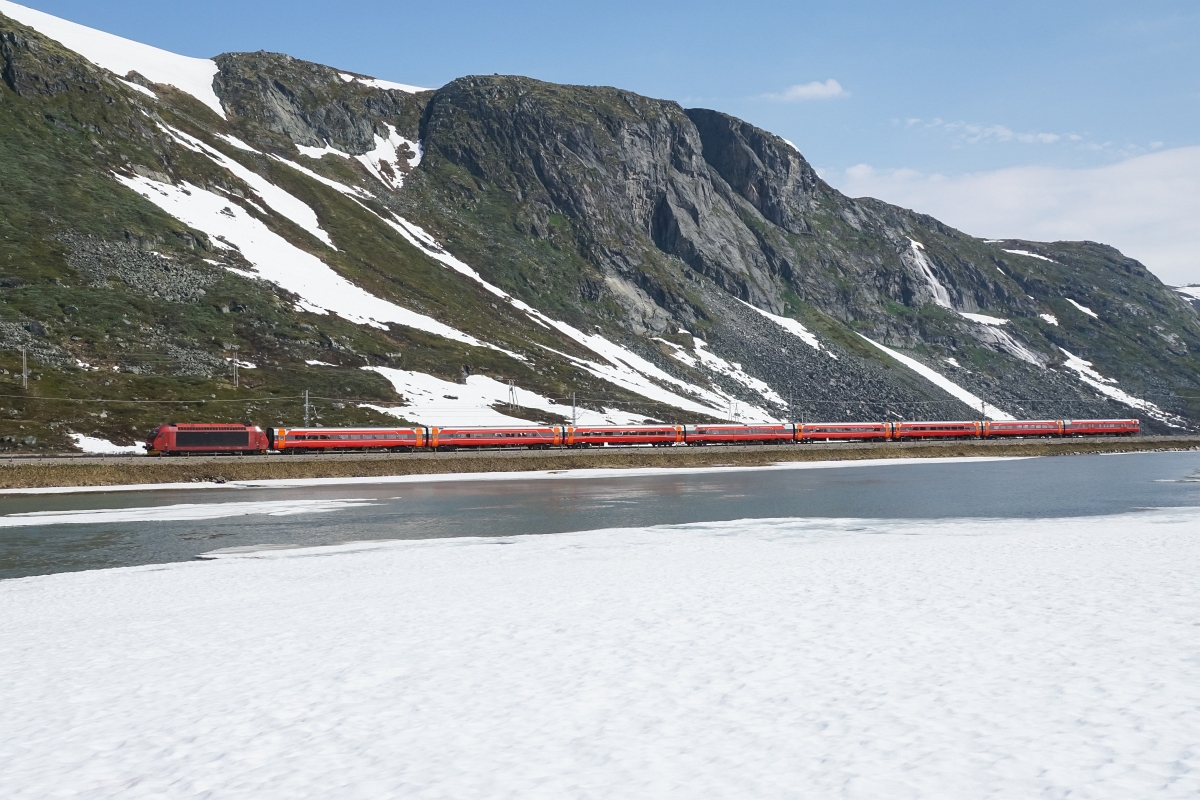 Sommerferien in Skandinavien, 1. Teil: An der Bergenbahn: El 18 2262 zieht am 04.07.2015 den Rt 609 von Haugastøl Richtung Finse und passiert dabei einen der vielen wunderschönen Bergseen.