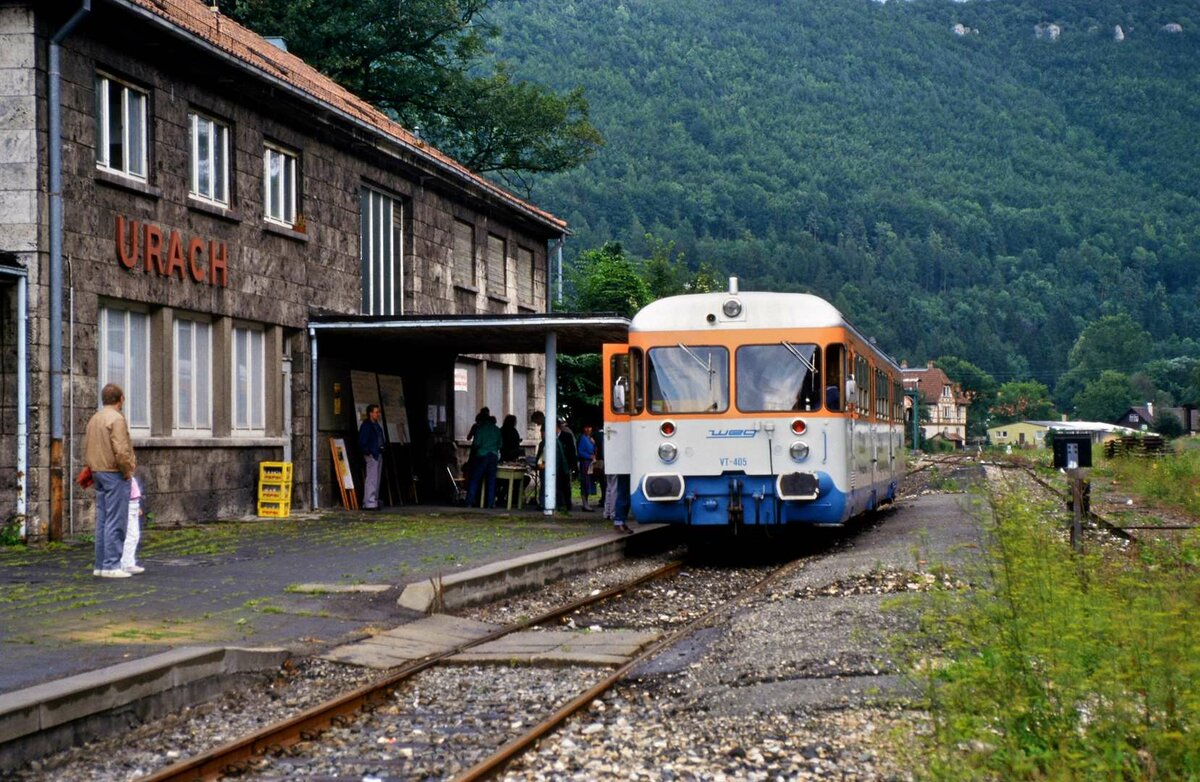 Sonderfahrt auf der Ermstalbahn: VT 405 (WEG) wartete vor dem früheren DB-Bahnhof Bad Urach. Das Bahnhofshaus ist zwar noch vorhanden, aber die Züge halten nicht mehr hier, sondern weiter vorn rechts vom Bahnhofsareal. Vor dem Bahnhof verläuft mittlerweile eine Bundesstraße (nach Münsingen). 
Datum: 21.08.1988