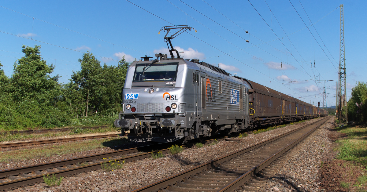 Sonntagmorgen - E 42 151 war mit dem Classic Courier angekündigt.

Das Wetter passte und so ging es nach Bous an die Strecke.
In Höhe der alten Bahnmeisterei und des Stahlwerk Bous (früher Mannesmann Röhrenwerke) gibt es einen schönen Platz.
Dieser ist etwas breiter, weil der Fahrdraht früher noch ein weiteres Gleis überspannen mußte und die Masten zurück gesetzt stehen.

Beim Warten auf den Sonderzug brauste Akiem 37025 mit dem Saarrail Zug heran. (Saarrail ist die Bahnsparte von Saarstahl)

Die Lok trägt auch Beschriftungen von VIA Cargo und HSL.
Aus dem hohen Norden kommend ist das Ziel, die Betriebsstätten von Saarstahl, fast erreicht.

15.06.2014 - Bahnstrecke 3230 Saarbrücken - Karthaus