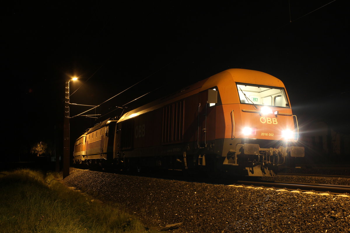 Spät in der Nacht des 29.8.2019 steht der DG54976 von Graz Vbf nach Linz Vbf im Bahnhof Wald am Schoberpass und wartet die Vorbeifahrt des EN464 ab. Bespannt ist der Zug mit 2016 052 die nur bis Selzthal am Zug war, 1144 212 und die geschleppte 1142 608. 