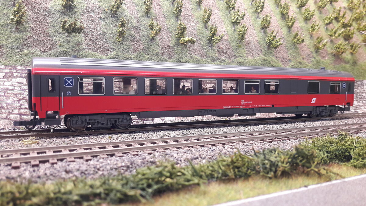 Speiswagen der ÖBB in der weiterführenden Lackierung Blutrot/grau. Hier der Speisewagen WRmz 
 bestückt mit Fahrgästen, Koch usw, Modell Roco 44647 , rechte Seite