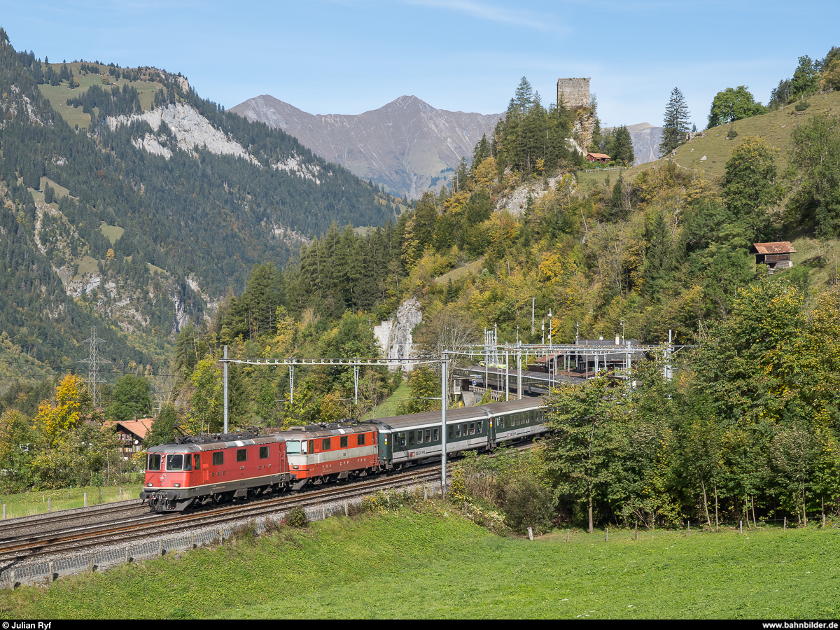 Sportferienlager-Extrazug Brig - Zürich mit Re 4/4 II 11304 und 11108 am 12. Oktober 2019 bei der Durchfahrt des Bahnhofs Blausee-Mitholz. Darüber thront die die Felsenburg.