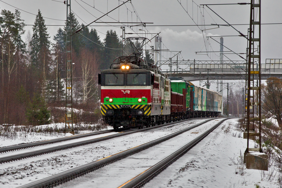 Sr1 3005 und die Sr1 3024 donnern in Kausala bei feinem Schneefall mit einem gemischten Güterzug vorüber.Bild vom 27.1.2016