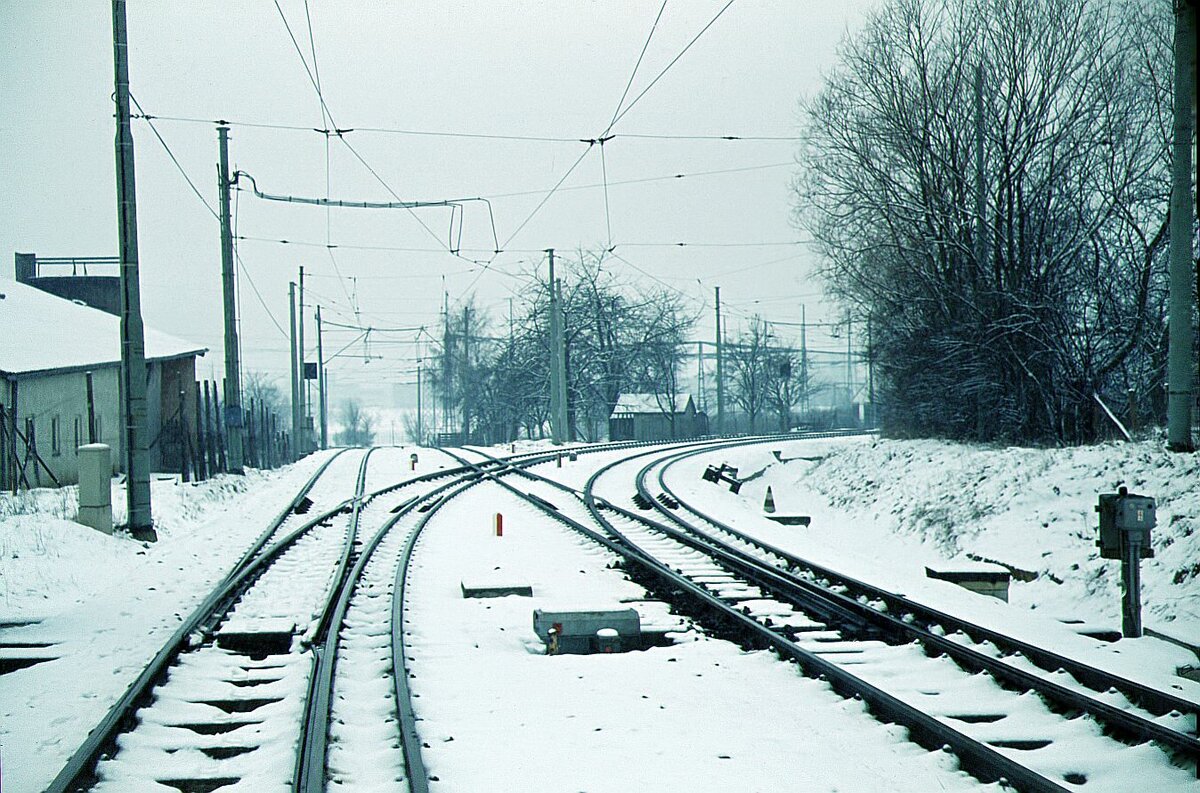 SSB Filderbahn Abzweig Vaihinger Str.in Möhringen: links nach Leinfelden-Echterdingen nur Meterspur / re. nach Vaihingen 3-Schienengleis 12.03.1972 Aufnahme am Ende der Strab-Unterführung Vaihinger Str. in Möhringen.Damals – es war 1 9 7 2 ! – dort noch bis auf ein Gehöft alles unbebaut, Wiesen und Pferdekoppeln, führte ein Fußweg an den Gleisen entlang. Ein paar SSBler waren mit irgendwelchen Untersuchungen am Gleis beschäftigt für die Installation, ich weiß nicht mehr, neue Signalanlage oder ZUB-Baken o.ä. und hatten nichts dagegen, daß ich  unter ihrer Aufsicht   ein Foto von der im Schnee gut erkennbaren Verzweigung der gemischten Spurweiten machte.