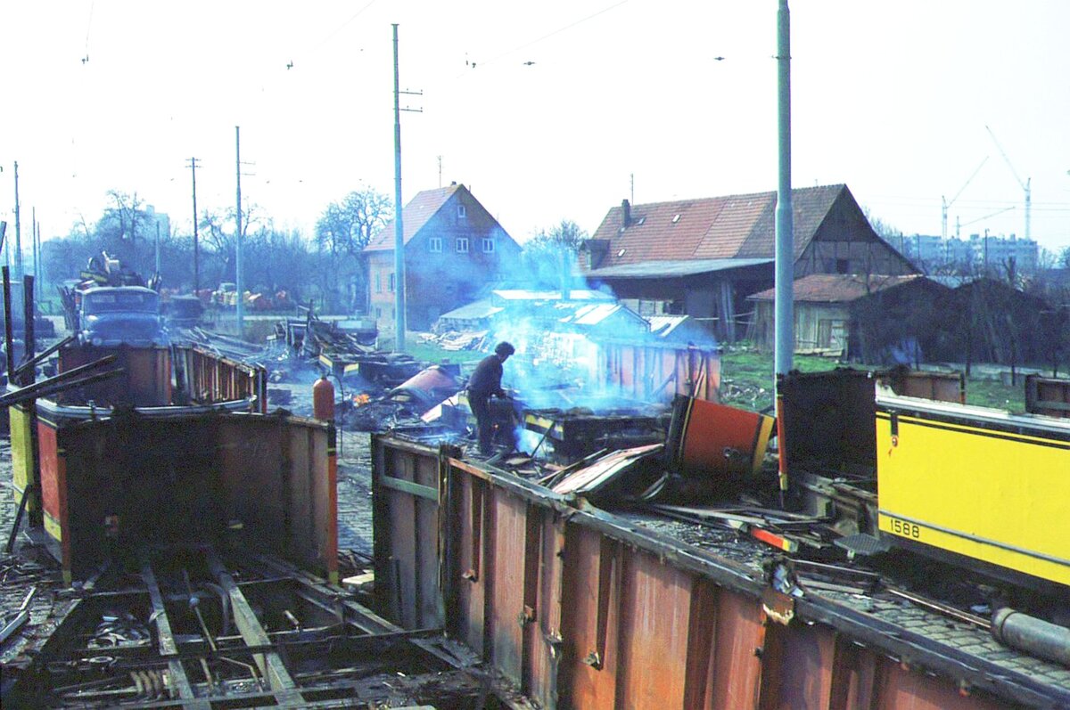 SSB Stuttgart__Endstation. Neben den Ausfahrtsgleisen im Bf S-M�hringen Richtung Vaihingen befanden sich jahrzehntelang die sog. Schrottgleise f�r ausgediente Stra�enbahnwagen. Wie alles um das fr�here Bahhnhofsgel�nde sind auch diese Gleise sowie das dahinter liegende Gr�nland samt G�rtnerei l�ngst dichter Wohnbebauung gewichen. Im Bild rauchende Reste von R1500er Bw ( Schiffle ). Rechts noch zu erkennen (Rest) Bw 1588 [Fuchs HD  1957]._27-03-1974