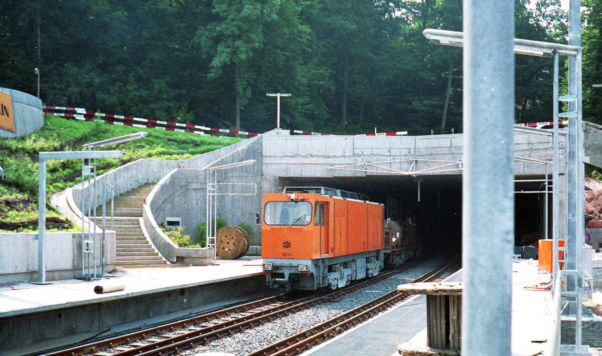 SSB Stuttgart__Gleisbau_Die Diesel-Elektrische Arbeitslok 2011 [4x E-DE-Lok Bj.1981; Kaelble-Gmeinder/Siemens] lugt (noch auf M-Spur) aus dem Stadtbahn-Tunnel von Degerloch zur Haltestelle 'Weinsteige' (zuvor 'Waldau'). Die Stadtbahn wird hier erst 2 Jahre später verkehren. Die Lok 1991 auf N-Spur umgestellt.__08-1988