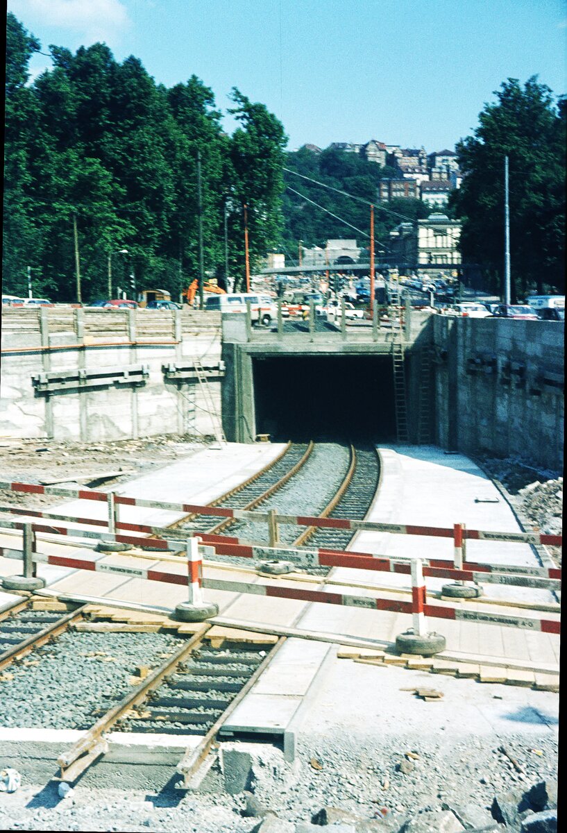 SSB Stuttgart__Gleisbau__Man sieht schon, was es werden soll. Die provisorische Tunnelrampe vor dem Hbf zur U-Haltestelle 'Staatsgalerie' für die Linien 9 und 14. Die Haltestellen erstmals mit Fußbodenheizung (versuchsweise) wegen des starken Gefälles von 8%.__08-1972