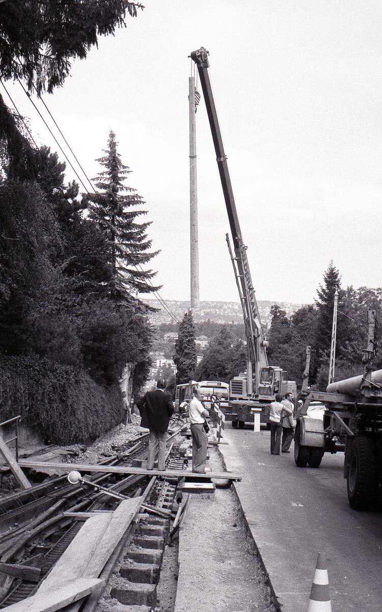 SSB Stuttgart__Zahnradbahn__Juli und August 1980 fuhr keine Zahnradbahn, die gesamte Trasse wurde für die neuen ZT4 Tw umgebaut. Die Betonmasten kommen. Direkt unterhalb der Ausweiche 'Wielandshöhe' finden zwei extra starke Exemplare ihren Platz. SSB-Vorstand Dr. Groche und Pressesprecher Brodbeck schauen interessiert zu.__04-08-1980