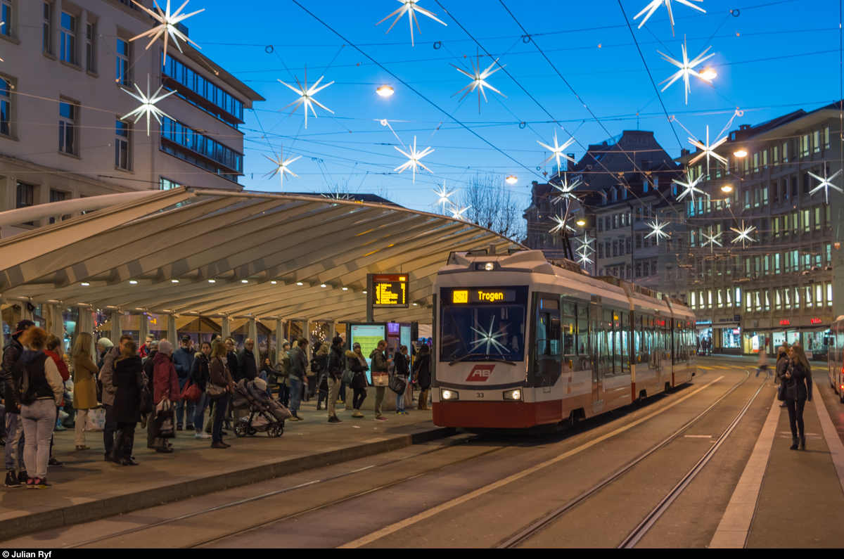 St. Gallen Marktplatz Bohl am Abend des 7. Dezember 2015. In der Stosszeit verkehren hier die Busse fast im Minutentakt und zwischendurch kommt auch noch die Trogenerbahn vorbei. Ein Zug derselben ist hier beim Halt am  Wartehäuschen  von Santiago Calatrava zu sehen.