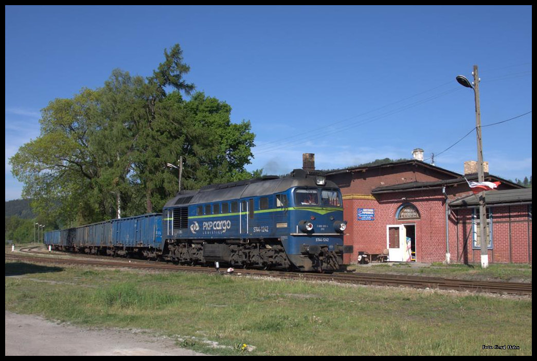 ST44-1242 ist mit ihrem Güterzug aus Scinawka Srednia (Mittelsteine) am 23.5.2016 gegen 09.00 Uhr in Nowa Ruda Slupiec (Neurode - Schlegel) angekommen. Der Zug musste im Bahnhof halten, um sich auf dem dortigen Stellwerk anzumelden. Erst danach wurden die Schranken (rechts vom Bahnhof) geschlossen und die Weiterfahrt konnte beginnen. 