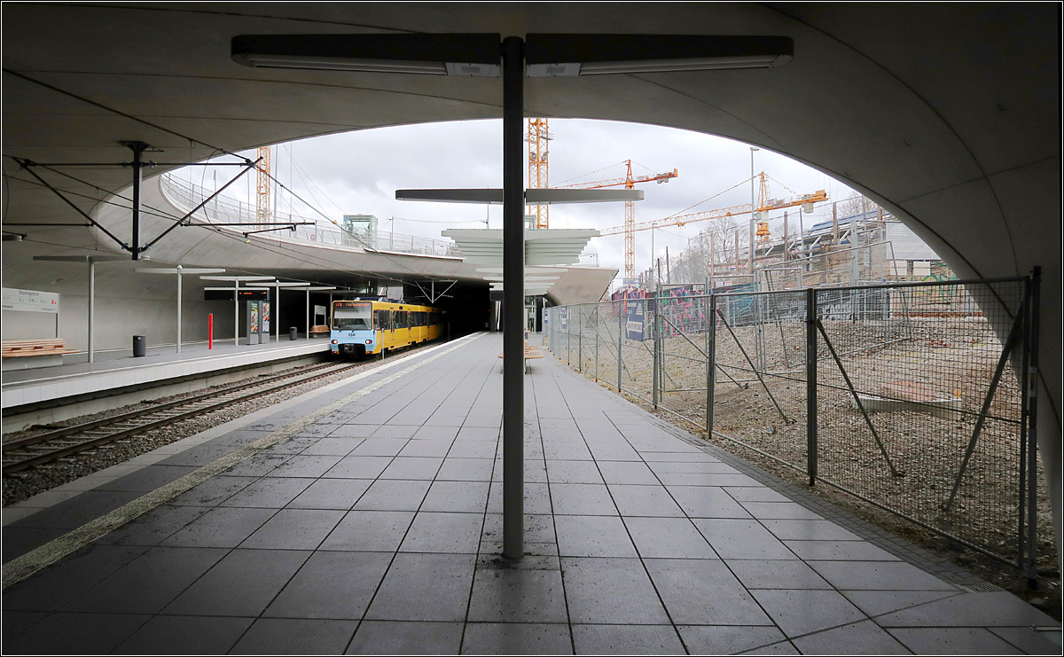Staatsgalerie - die Haltestelle mit dem Schwung - 

Blick in die neue nach oben offene Stadtbahnhaltestelle Staatsgalerie, die die schwungvolle Formen des neuen Hauptbahnhofes von Stuttgarter schon vorwegnimmt. Im Bereich der Baukräne befindet sich der Südkopf des neuen Hauptbahnhofes. So ergibt sich auch hier eine Verknüpfung zwischen Stadtbahn und der großen Eisenbahn. Vielleicht sollte deshalb die Station in Hauptbahnhof-Süd (Staatsgalerie) umbenannt werden.
Rechts wo sich noch der Zaun befindet, wird sich nach Beendigung der Bauarbeiten eine Wiese den Hang zum Planetarium hinauf ziehen.

22.02.2022 (M)