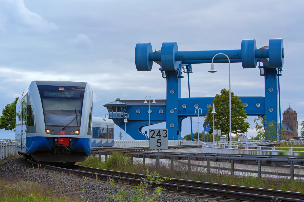 Stadler GTW der UBB hat die Eisenbahn- & Strassenbrücke in Wolgast verlassen und fährt auf den Hp Wolgast Fähre zu. - 27.05.2015 - An den Fahrradständern des Hp Wolgast Fähre aufgenommen.