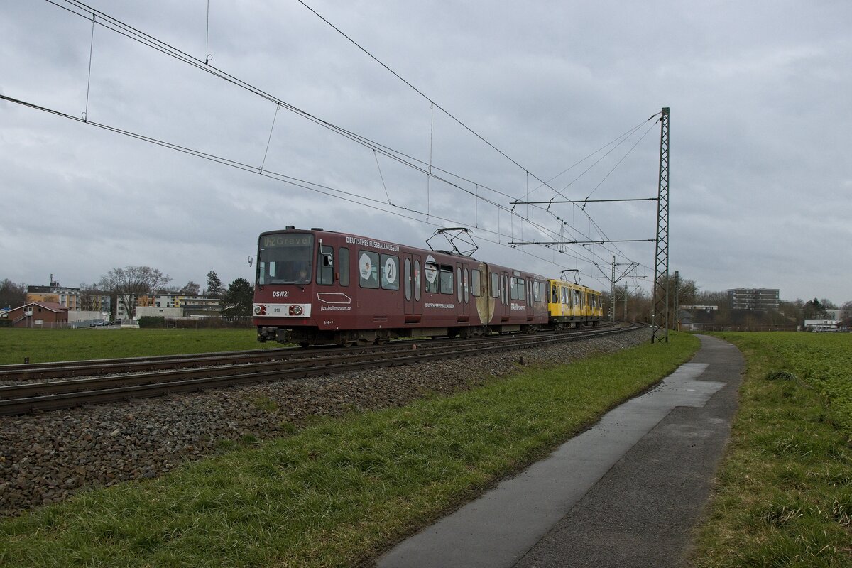 Stadtbahnwagen 319 mit Werbung für das Deutsche Fußballmuseum bei der Einfahrt in die Haltestelle Grevel (22.02.2022)