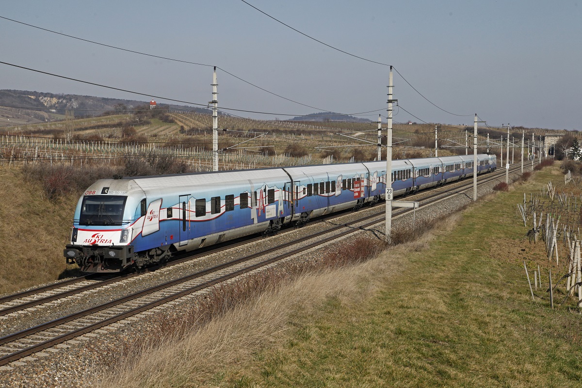 Steuerwagen 80-90.751 (SKIAUSTRIA) ist am 25.02.2014 als RJ651 durch das Weinbaugebiet bei Pfaffstätten Richtung Süden unterwegs. Am rechten Bildrand ist der Busserltunnel zu sehen.