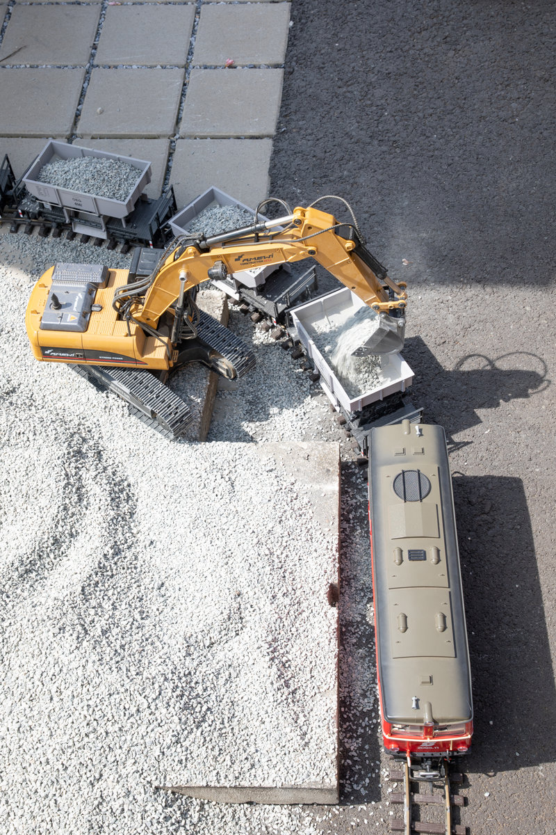 Stilecht wurde Schotter per Bahn zur Baustelle der Gartenbahn gebracht. Dabei half ein Kettenbagger aus. 
18.08.2019