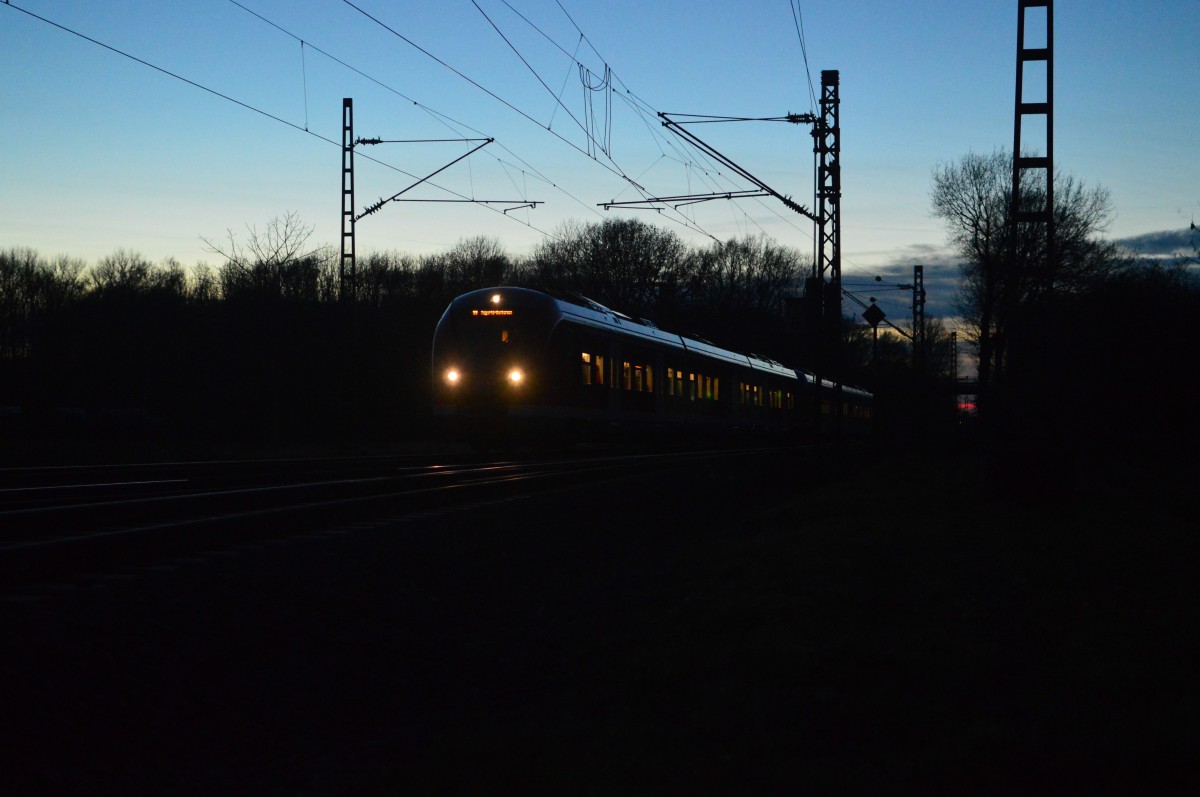 Stimmungsbild aus Kleinenbroich, Sonnenuntergang von der Bahnhofseinfahrt in Kleinenbroich aus aufgenommen. Der einfahrende Zug ist eine S8. 25.1.2016
