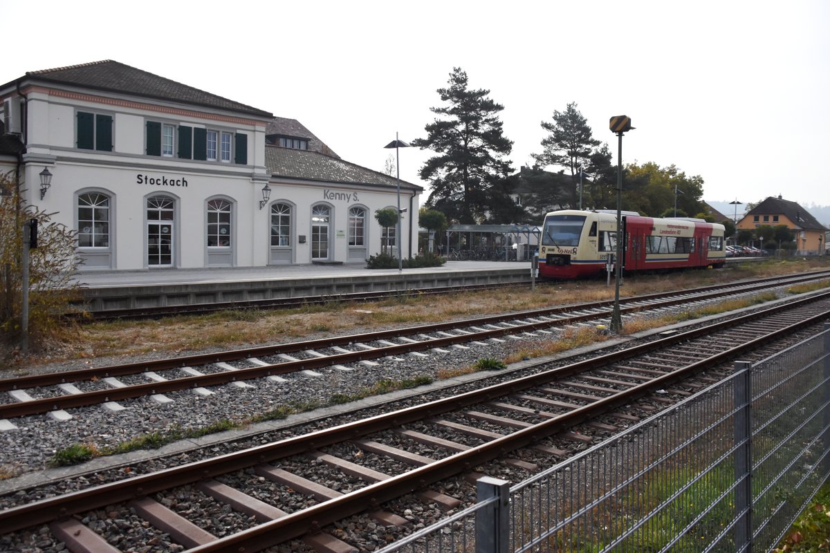 STOCKACH (Landkreis Konstanz), 23.10.2018, Blick auf das Bahnhofsgebäude, das nicht mehr als solches genutzt wird, rechts ein ausfahrender Zug der Hohenzollerischen Landesbahn nach Radolfzell am Bodensee