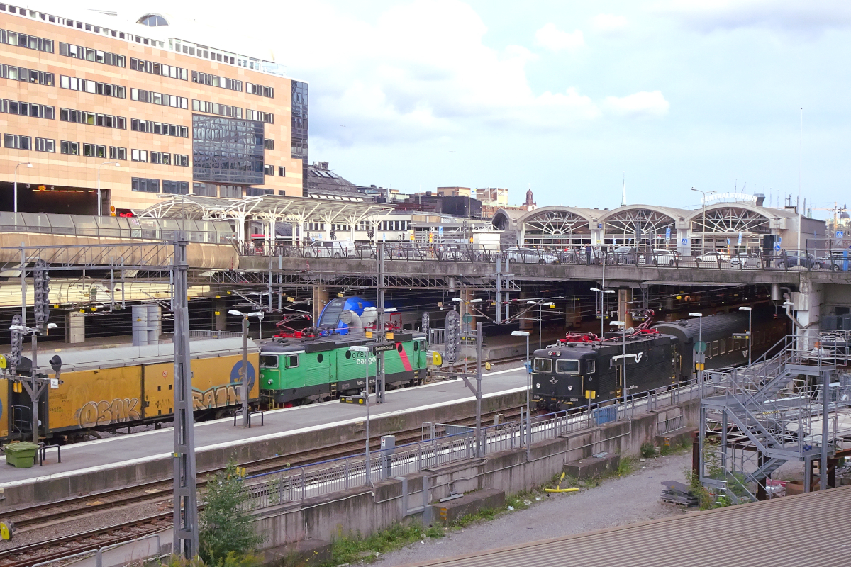 Stockholm C: Die Rc4P 1291 der Green Cargo durchfährt Stockholm C auf Gleis 17, gleich wird sie unter dem Klarabergviadukten verschwinden. Auf Gleis 19 wartet die Rc6 der SJ mit einem Reisezug Richtung Norden.
Stockholm C, Sonntag, 27. August 2023
