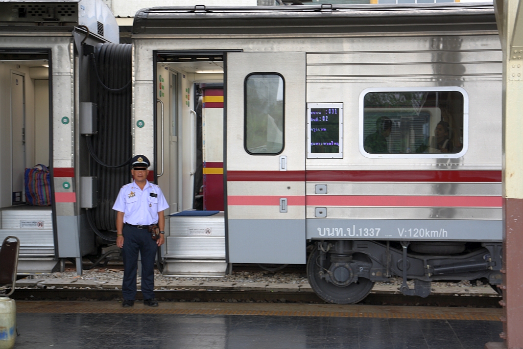 Stolz und in adretter Uniform posiert der Schaffner am 27.März 2017 in der Hua Lamphong Station vor dem บนท.ป. 1337 (บนท.ป.=ANS./Air-conditioned Second Class Day & Night Coach, Hersteller: CRRC Changchun, Bauj. 2016).