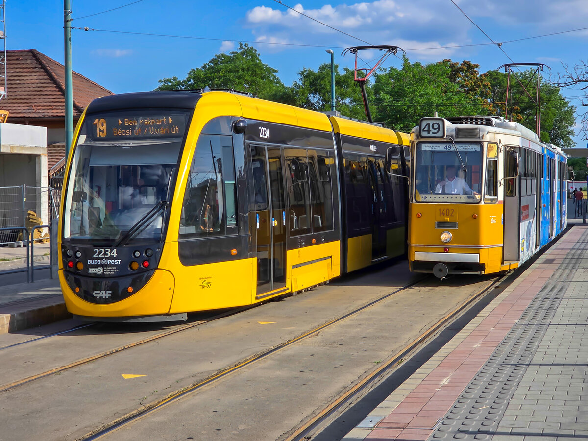 Stra�enbahn Budapest Zug 2234 auf der Linie 19 nach B�csi �t neben Zug 1402 auf der Linie 49 nach De�k Ferenc t�r in Kelenf�ld, 19.06.2026.