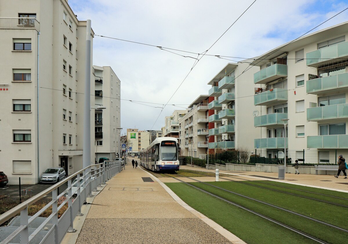 Strassenbahn Genève, Durchfahrt durch die französische Stadt Annemasse. Gerade überquert der Bombardier Cityrunner 869 die SNCF Bahnlinien nach Bellegarde bzw. St.Gervais. 10. März 2023 