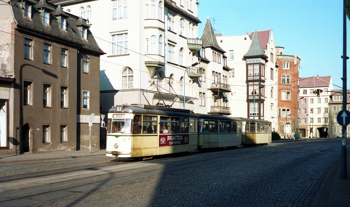 Straßenbahn Jena__Zug der Linie 1 nach Winzerla in der Straße 'Am Löbdergraben'. Im Hintergrund der (noch originale) Rote Turm der alten Stadtbefestigung von 1430. Fünf Jahre nach dieser Aufnahme stürzte der Turm bei Restaurierungsarbeiten ein, vier Bauarbeiter wurden getötet. Im Jahr 2000 erfolgte die Rekonstruktion des Turms.__17-03-90