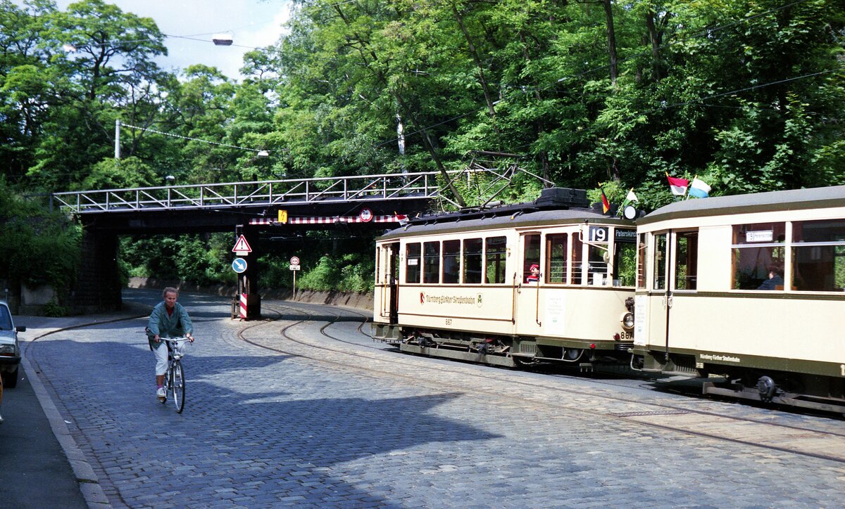 Straßenbahn Nürnberg__Histor. Tw 867 [MAN/SSW,1929] und Bw 1258 [MAN,1951] im einheitlichen beige-farbenen Look der  Nürnberg-Fürther  auf der Rückfahrt von Erlenstegen vor der längst verschwundenen Ringbahnbrücke. Seit mindestens den 30er Jahren gibt es Überlegungen, Teile der Ringbahn (insbesondere den Nord-West-Abschnitt) als Teil weitergehender Verbindungen für Personen-Nahverkehr zu nutzen. Aktuell erwogen wird eine Verbindung der Rangaubahn (aus Cadolzburg) zur Gräfenbergbahn (aus Gräfenberg) über Thon und Muggenhof.__Sommer 1985 
