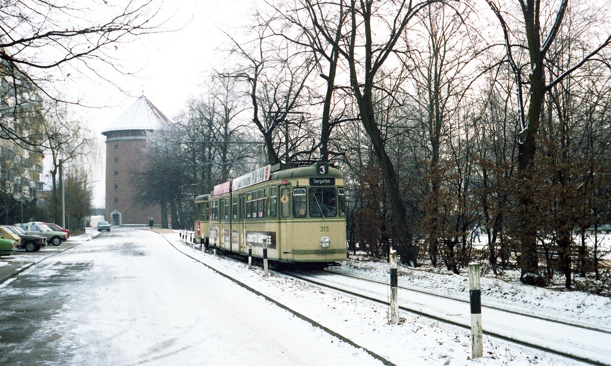 Straßenbahn Nürnberg__Tw 315 [GT6; MAN 1963; 1999 nach Krakau >Nr. 176] durchfährt die Endschleife in Schweinau und beginnt seine Fahrt zum Tiergarten. Im Hintergrund ein WKII Hochbunker (heute als Garnisonsmuseum genutzt). Es ist traurig, feststellen zu müssen, daß mancher Hochbunker in jener Zeit äußerlich sensibler an seine Umgebung angepaßt wurde, als zu viele innerstädtische Geschäftsbauten/Kaufhäuser der Nachkriegszeit ...__07-01-1984 