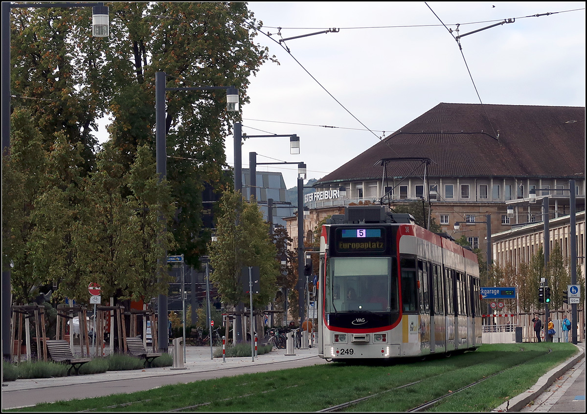 Streckendokumentation zweite Nord-Süd-Strecke in Freiburg - 

Auf Rasengleis durch den für den Autoverkehr zurückgebauten Roteckring. Im Hintergrund das Freiburger Theater. An den Oberleitungsmasten wurden formschöne Straßenbeleuchtungen angebracht.

07.10.2019 (M)