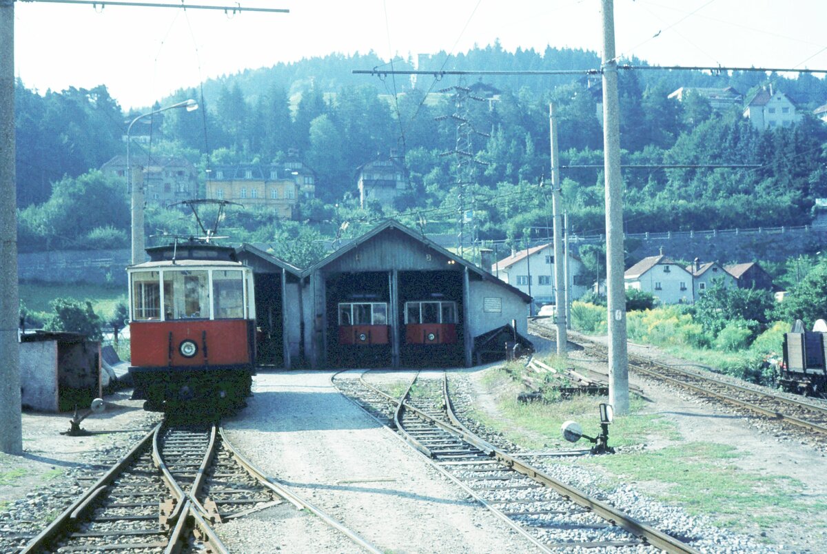 Stubaitalbahn__Stubaitalbahnhof Bergisel, Tw 1, 2 und 4 [Graz/AEG; 1904 und 1905] vor bzw. in der Wagenhalle. Im Hintergrund die Streckenausfahrt nach Fulpmes._18-08-1973