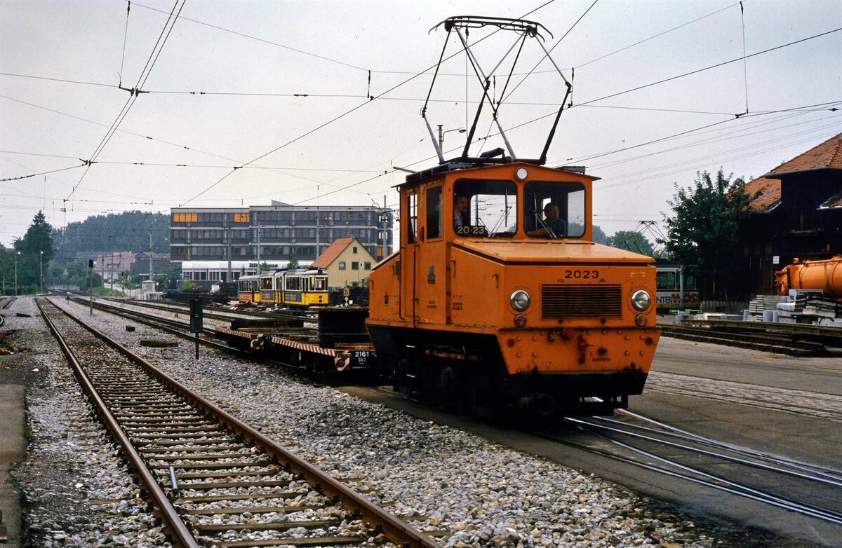 Stuttgarter Straßenbahnen (SSB): Bauzuglokomotive 2023 (MF Esslingen und BBC 1946) mit den Wagen 2161 und 2162 auf den Gleisen neben dem Möhringer Bahnhof (frühere Filderbahn). Die Schlepplok  war als  Trümmerlok  des Typs  Bern  gebaut worden und gelangte 1949 zur SSB. Sie ist in der Stuttgarter Straßenbahnwelt erhalten.
Datum: 26.07.1984.