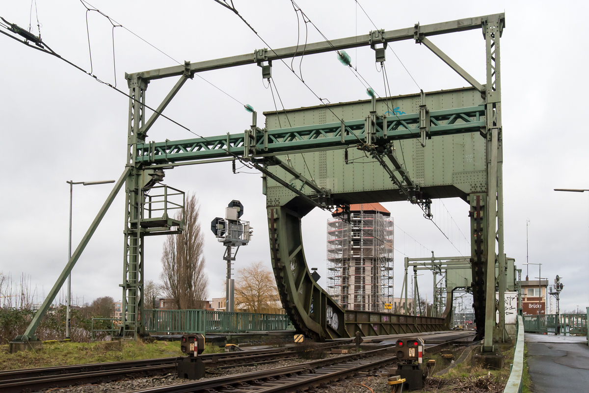 Südportal (Gegengewicht des südlichen Brückenträgers) und Oberleitungstrennstelle der Klappbrücke über die Hunte am 13.02.2020. Im Hintergrund der eingerüstete Wasserturm des Bf Oldenburg.