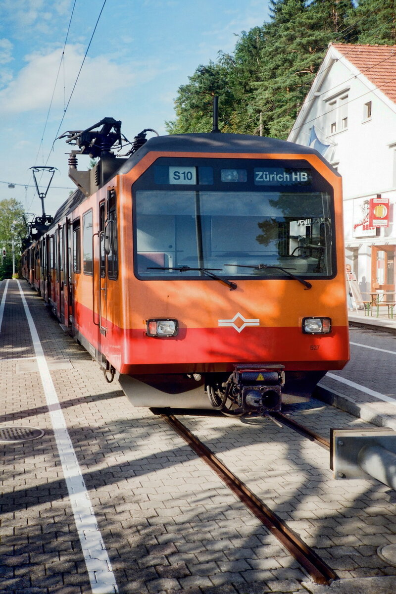 SZU-Uetlibergbahn Triebwagen 527 (Be4/4 SLM 1992) an der Bergstation auf dem Uetliberg. 
Gut sichtbar mit seitlich versetzten Stromabnehmern für die einzigartige seitliche Oberleitung für 1200V Gleichspannung, die gewählt wurde, um einen Betrieb auf den gemeinsam mit der Sihltalbahn, welche unter Wechselspannungsfahrleitung fährt, befahrenen Gleisen zu ermöglichen. 
Ab 2022 soll übrigens auch die Uetlibergbahn auf das übliche 15000V Wechselspannungssystem umgestellt werden.

historisch - Scan

1997-09-17 Zürich-Uetliberg