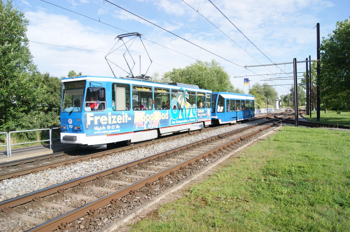 T6A2 702 mit unbekanntem NB4 der Rostocker Straßenbahn verlässt am 07.07.2014 die Haltestelle Marienehe auf Linie 1 in Richtung Lütten Klein.