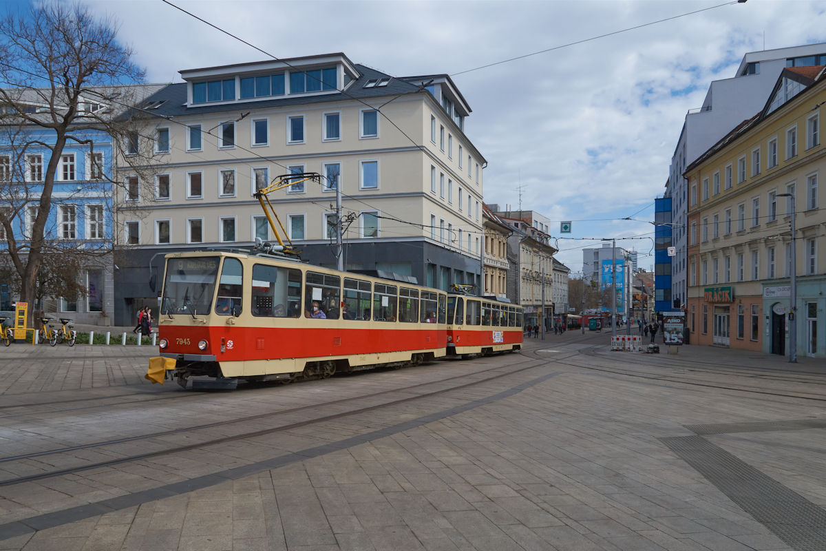 T6A5 7943 der Straßenbahn Bratislava war am 07.04.2022 mit einem weiteren Triebwagen auf der Linie 9 von Ružinov nach Karlova Ves unterwegs. Hier biegt der Zug aus der Obchodna in der Hurbanovo Namesie ein.