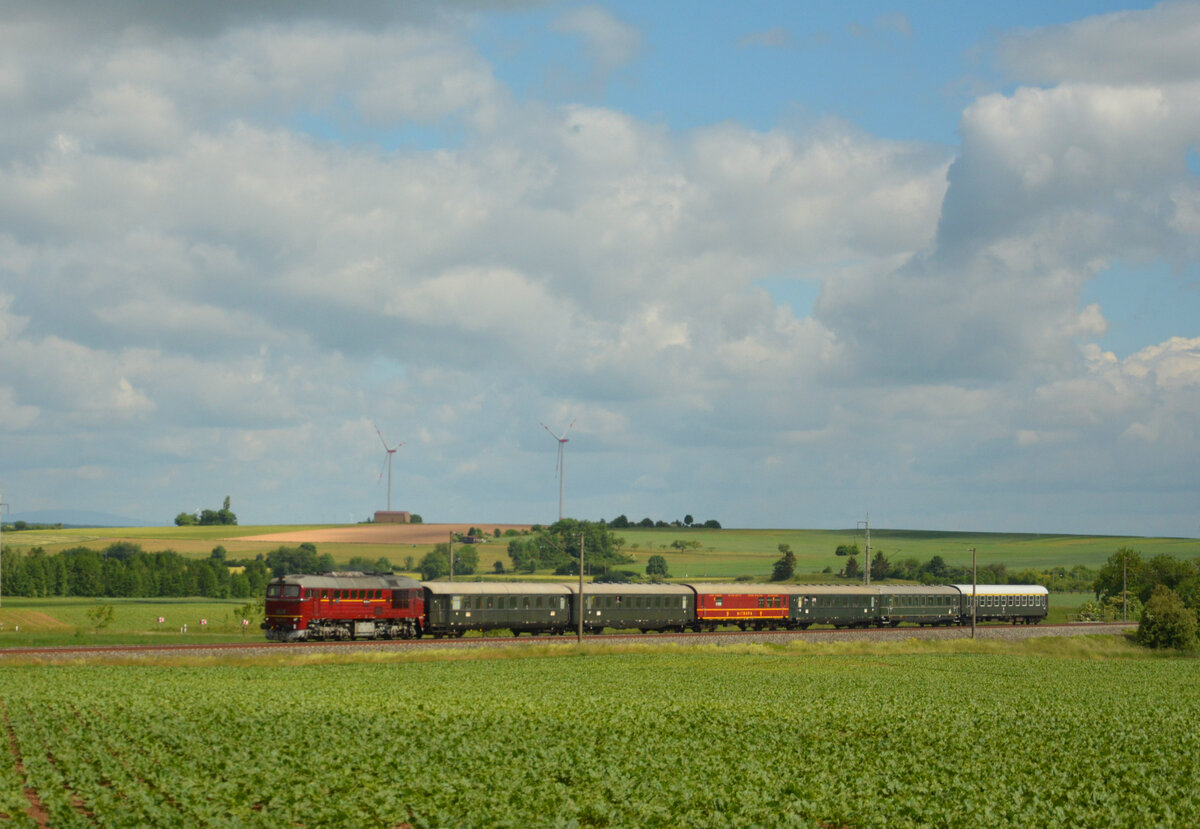  Taigatrommel  unterwegs: Anlässlich des Nördlinger Eisenbahnfestes (26. - 29. Mai 2022) waren wieder mehrere Sonderzüge ins Ries unterwegs. U. a. reiste der Meininger Dampflokverein e.V. zwar nicht mit Dampf, dafür aber mit Diesel, in Form der  Taigatrommel  120 274-6 und mit historischem Sonderzug von Meiningen über Schweinfurt, Würzburg und Gunzenhausen nach Nördlingen an. Der Zug rollt hier am 28.05.2022 bei Opferbaum zwischen Schweinfurt und Würzburg pünktlich an den zahlreichen Fotografen vorbei.