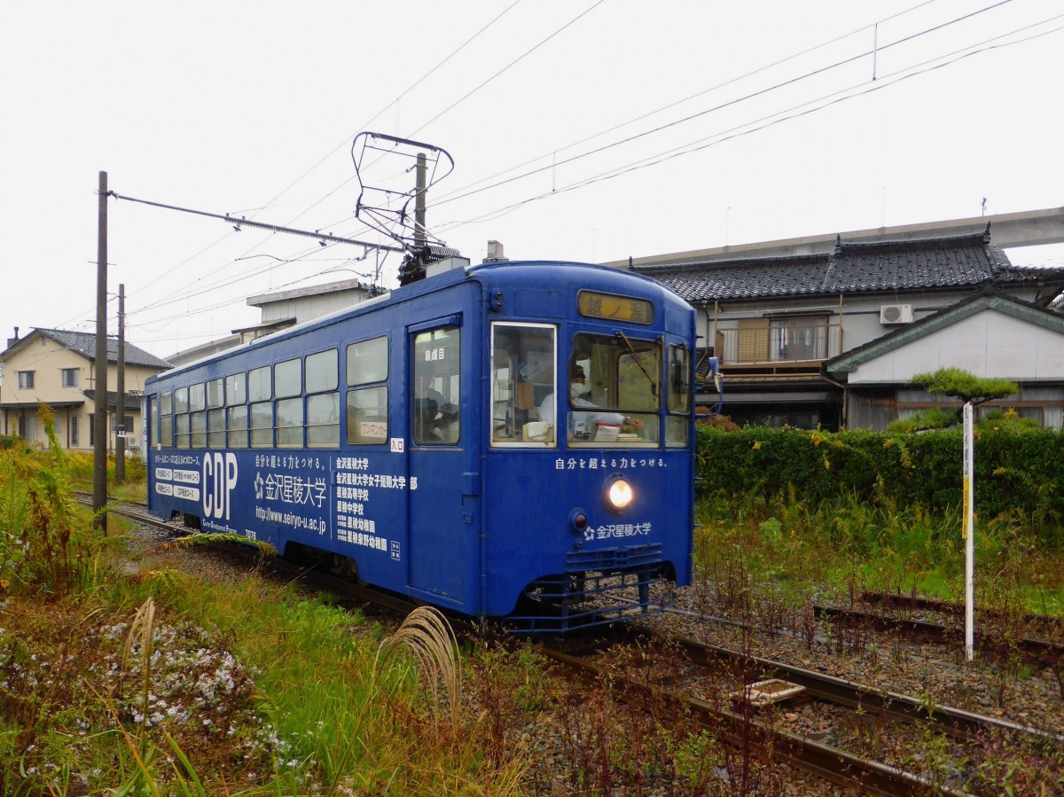 Takaoka Manyô-Linie, alte Wagen Serie 7070: Wagen 7076 wirbt für eine Privatuniversität in einer benachbarten Stadt; die Buchstaben CDP stehen für  Career Development Program . Koshinokata, 25.Oktober 2013. 
