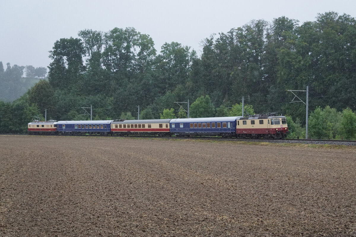 TEE  EMMENTAL ll .
TEE CLASSICS Sommerabendfahrt 2021 vom 7. August 2021 mit Re 4/4 ll 11393 TEE, Re 4/4 l 10034 TEE, dem ARmz 211 sowie weiteren  komfortablen Speisewagen der SGG. Befahren wurden bei starkem Regen die Geleise der Emmentalbahn.
Mit TEE-Lokomotiven an beiden Enden bei Ramsei.
Foto: Walter Ruetsch
