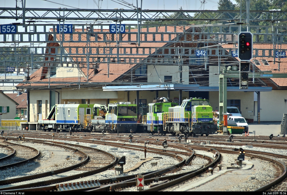 Tele-Blick auf diverse Baufahrzeuge der BLS Netz AG (BLSN), u.a. Am 843 503-4 (Vossloh G 1700-2 BB), Rangiertraktor Tm 2/2 94 (235 094-0) und Tm 235 203-7 (Robel 54.24-B0015), die im westlichen Gleisvorfeld des Bahnhofs Spiez (CH) abgestellt sind.
Aufgenommen am Ende des Bahnsteigs 4/5.
[24.7.2019 | 15:36 Uhr]
