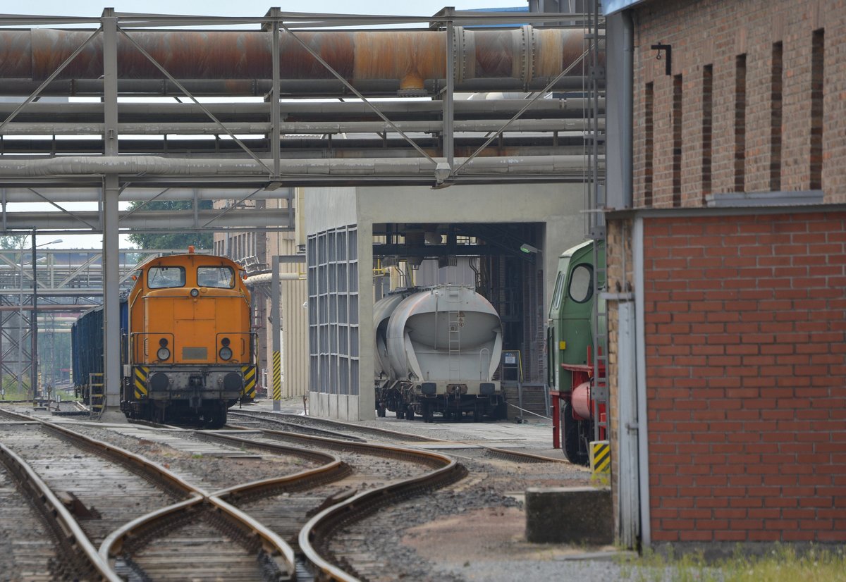 Teleaufnahme auf eine V60 in Staßfurt im Sodawerk. Rechts hinter der Mauer sind Teile einer Dampfspeicher Lok zu erkennen.

Staßfurt 20.07.2016