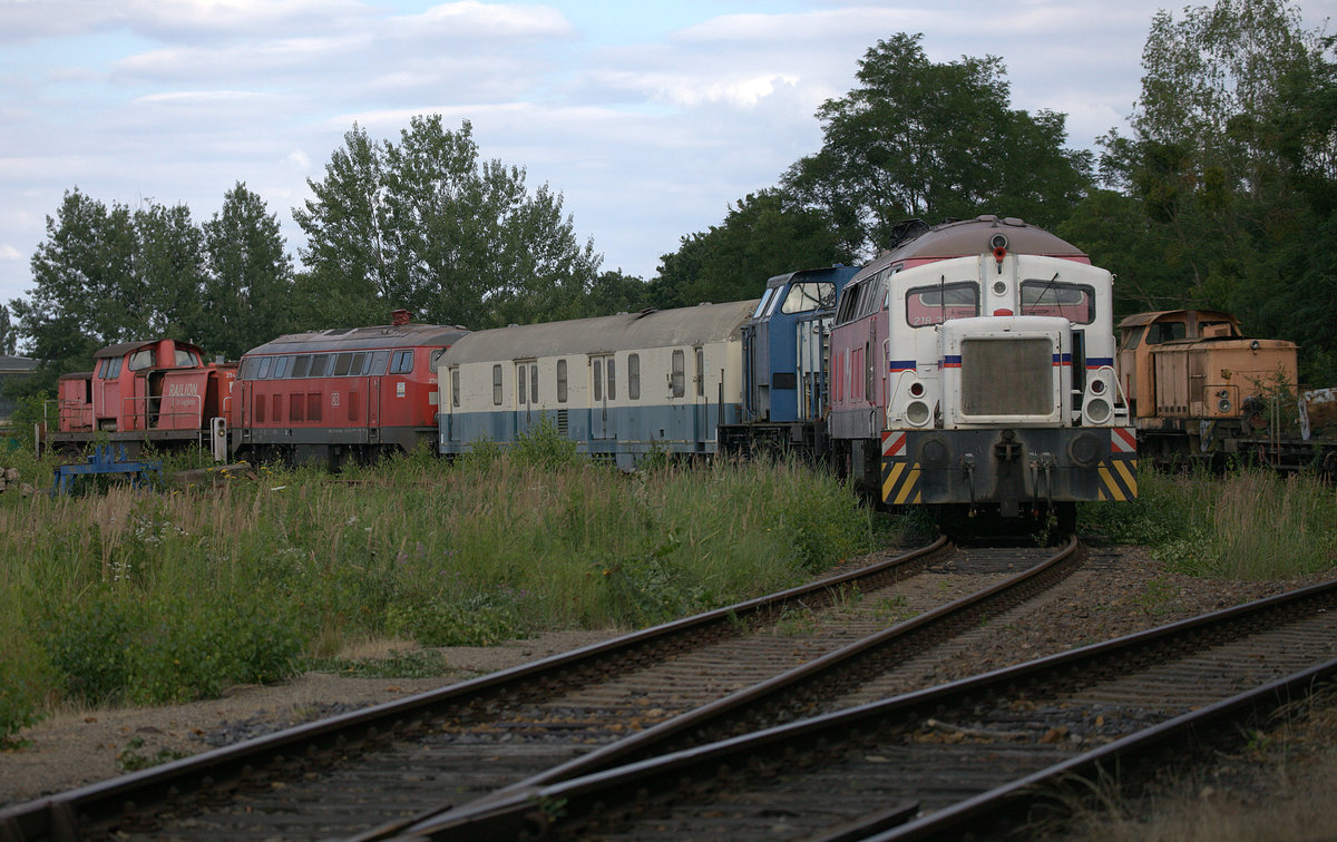 Teleblick auf eine abgestellte V16 in Brieske, Teleblick,auf das Betriebsgelände.
Dahinter eine ausgeschlachtete V100, ein Schnellzuggepäckwagen in der alten ozeanblauenbeigen Lackierung und eine Lok der Baureihe 218.23.07.2020 Brieske 17:16 Uhr.