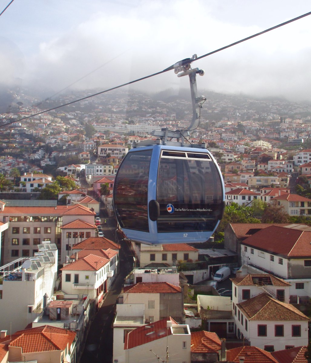 TELEFÉRICOS DA MADEIRA: Die Seilbahn zwischen Funchal und Monte aufgenommen am 18. April 2017 bei einer Seilbahnfahrt von Funchal nach Monte über der Stadt Funchal, Madeira. Die  leere  Nr. 12 im Bild unterwegs zur Talstation in Funchal.