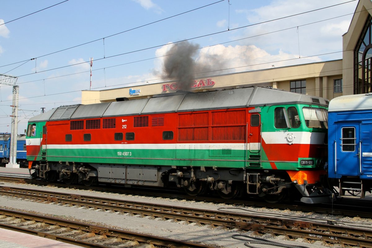 TEP70-0212 im Bahnhof von Gomel am 5.9.16. Eine schwarze Dieselwolke beim starten des Motors vernebelt die Sicht auf das Bahnhofs Schild. 